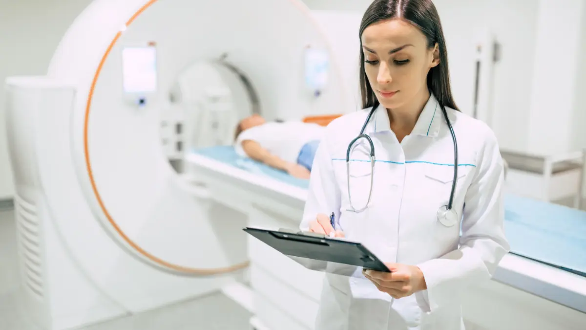 Medico con una cartella clinica davanti a un apparecchio per risonanza magnetica